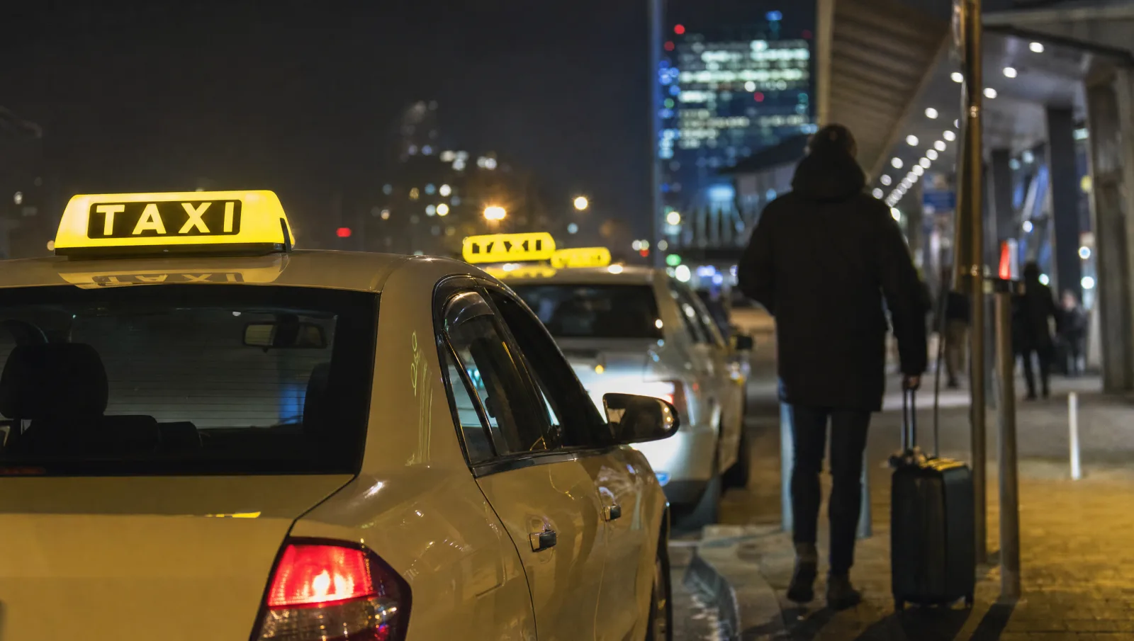 Taxis warten nachts am Taxistand, Buchung läuft per KI-Telefonassistent